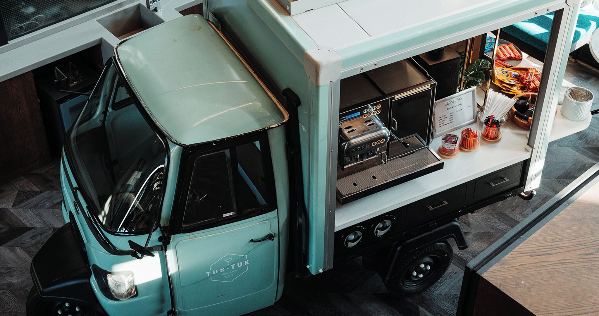 A mobile bar with a vintage design, a coffee machine, and a menu board.