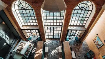 A multi-level atrium with large windows, a staircase, and seating areas.