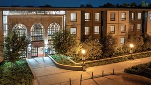 A hotel with a brick facade, large arched windows, and a well-lit entrance. - Hotel Perte Montecasino (Johannesburg)