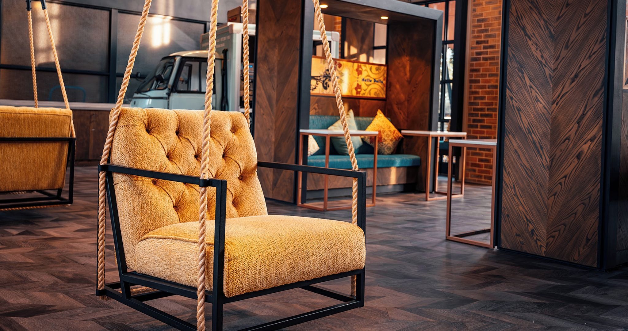 A room with a hanging chair, a sofa, and a table.