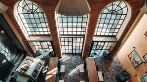 A multi-level atrium with large windows, a staircase, and seating areas.