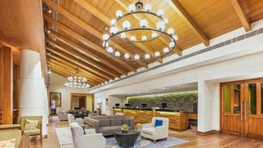A spacious lobby with a wooden ceiling, a reception desk, and a seating area with sofas and a coffee table. - Club Mahindra Resort - Tungi, Lonavala, Maharashtra (Mawal)