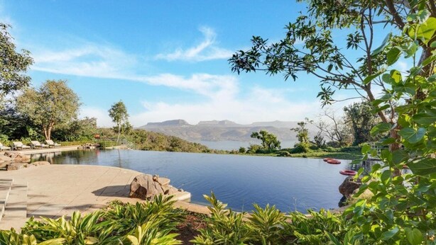 A infinity pool with a view of distant mountains, surrounded by lush greenery and a clear sky. - Club Mahindra Resort - Tungi, Lonavala, Maharashtra (Mawal)