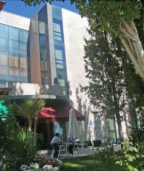 A modern building with large windows and a red awning. - Hotel Escuela San Cristobal (La Cisterniga)