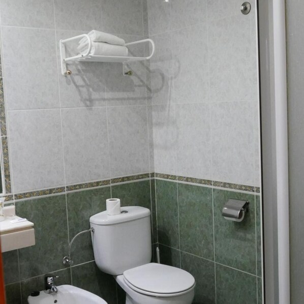 A bathroom with a toilet, bidet, and towel rack. - Hotel Escuela San Cristobal (La Cisterniga)