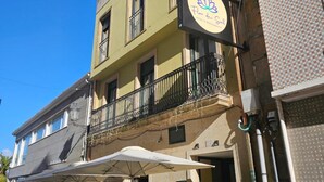 Un hôtel doté d’un balcon, d’une enseigne indiquant qu’il s’agit d’un hôtel-restaurant, et d’un numéro de chambre bien visible.