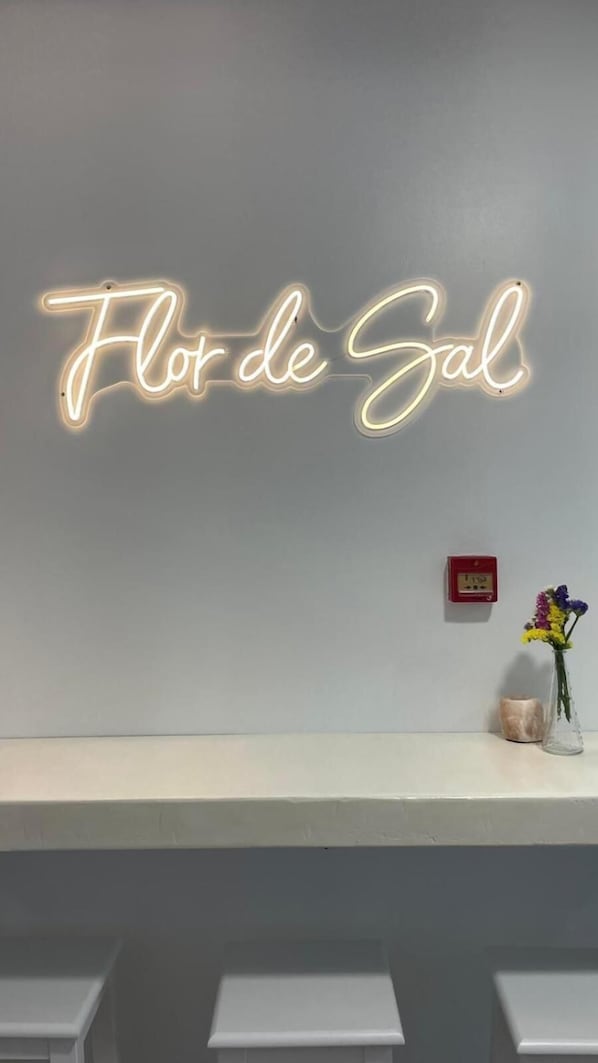 A neon sign with the text "Flor de Sal" on a wall. - Hotel Flor de Sal (Porto do Son)