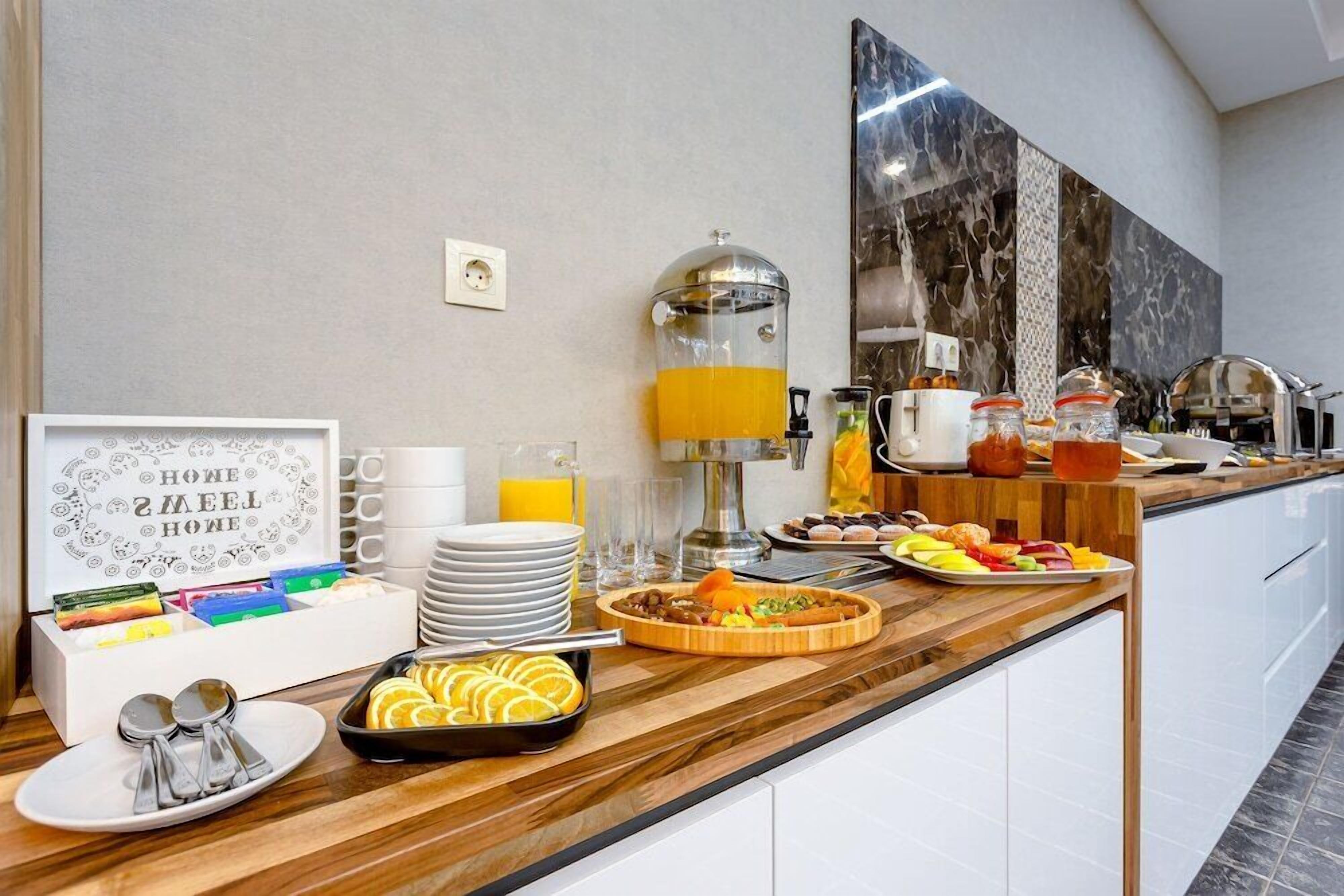 A breakfast buffet with various food items, a coffee station, and a juice dispenser.