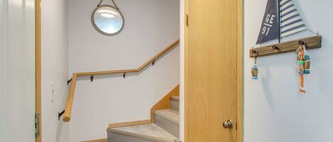 A staircase with wooden handrails and a round mirror on the wall.