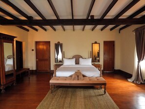 A hotel room with a large bed, wooden floor, and a wooden ceiling with exposed beams. - Graystone Bungalow by Seven Angels (Diyatalawa)