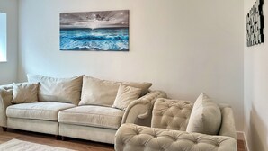 Ein Wohnzimmer mit einer Couch, einem Teppich und einem Bild an der Wand.