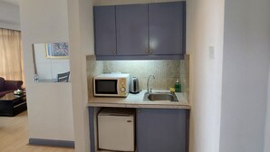 Una cocina compacta con microondas, tostadora y lavamanos.