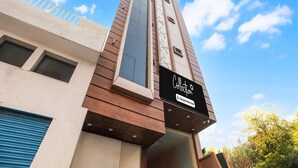 A modern building with a prominent 'Collection' sign, large windows, and a mix of wooden and concrete materials. - Collection O Banaras Railway Station (Varanasi)