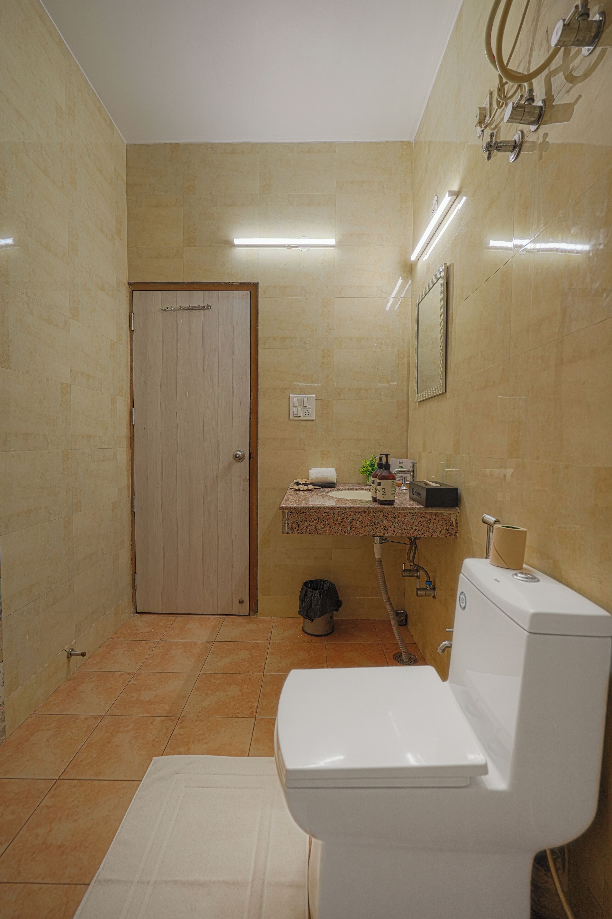 A bathroom with a toilet, sink, and mirror.