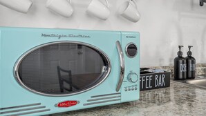 A retro-style kitchen with a turquoise appliance, a coffee bar, and hanging mugs. - Casa Esmeralda · Cozy · Midtown Gem (Tucson)