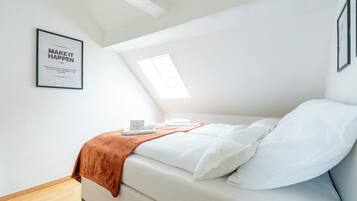 Een slaapkamer met een bed, een raam en een motiverende quote op de muur.