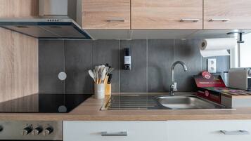 Una cocina moderna con armarios de madera, un lavamanos de acero inoxidable y un horno empotrado.
