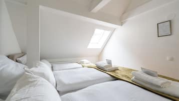 Una habitació amb dos llits, un sobrecap de fusta, un fanal i un certificat emmarcat a la paret.