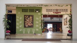 A reception area with a green wall, a mural, and a sign reading "MO 310". - Hotel Paro Residency (Leh)
