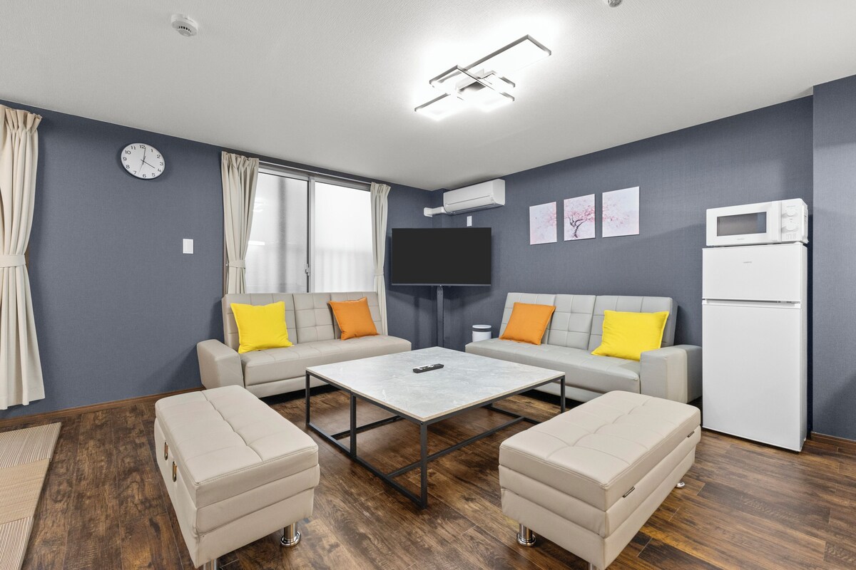 A modern living room with a sofa set, a coffee table, and a flat-screen TV.