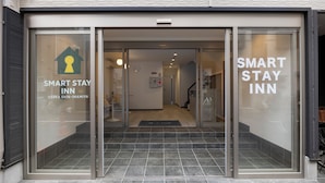 Der Eingang eines Smart Stay Inn mit freiem Blick in die Eingangshalle und einer Treppe, die hineinführt.