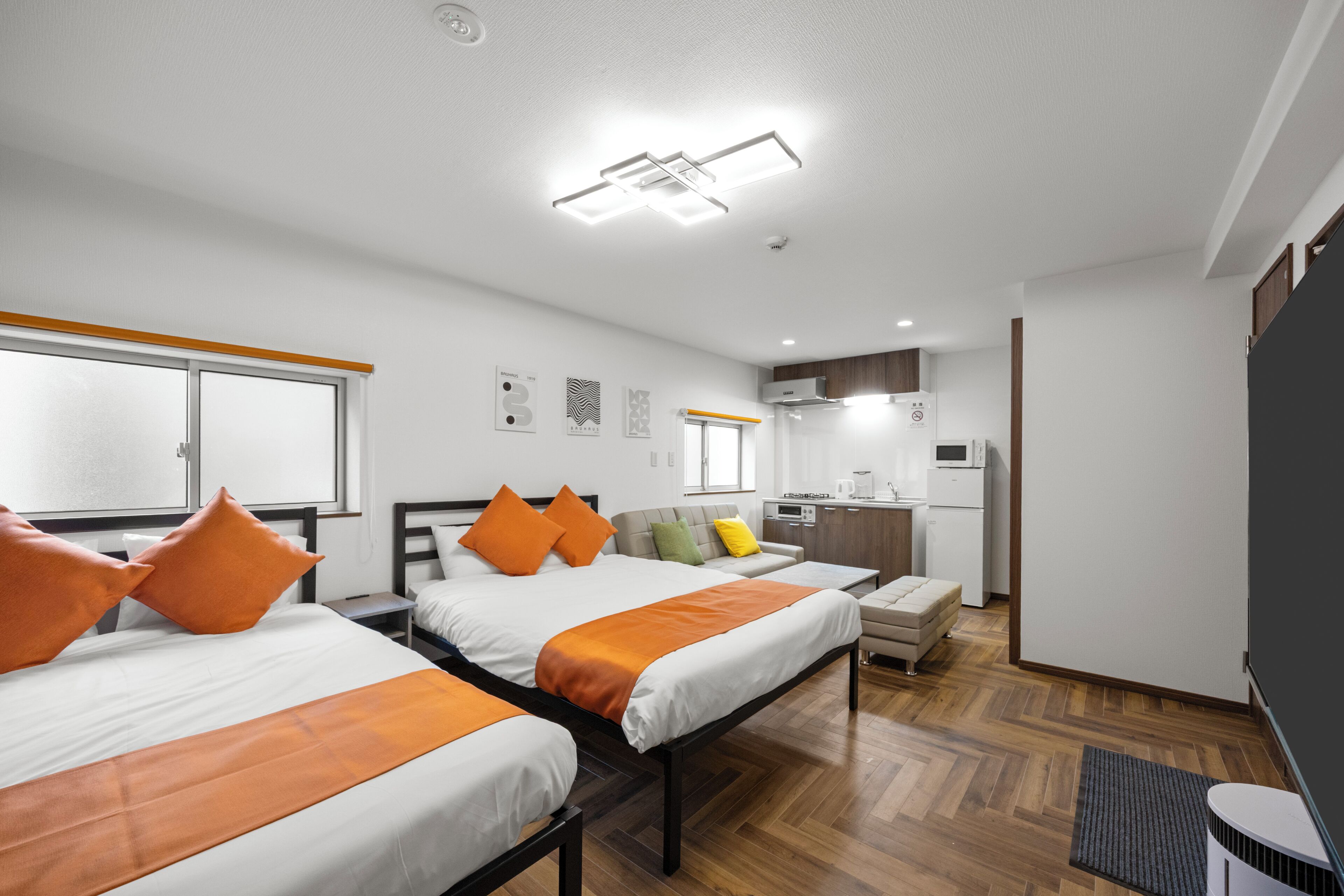 Une chambre d’hôtel avec deux lits, une kitchenette et une salle de bain.