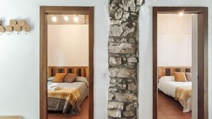 Ein Schlafzimmer mit Stehwand, einem Bett mit Holz-Kopfteil und einem Nachttisch.