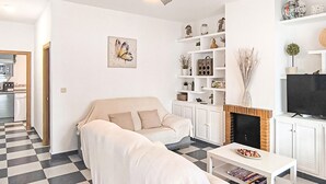 Una sala de estar con un sofá, una mesa de centro, una chimenea y un televisor.