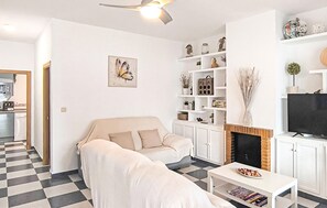 Un salon avec un canapé, une table basse, une cheminée et un téléviseur.
