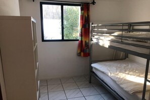 A dormitory room with bunk beds, a window with a curtain, and a wardrobe. - Classy Holiday Home in Santa Cristina d'Aro (Santa Cristina d'Aro)
