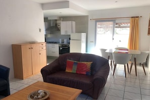 Ein Wohnzimmer mit einer Couch, einem Couchtisch und einem Essbereich mit Tisch und Stühlen.