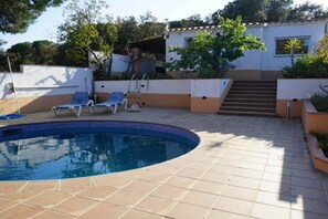 A swimming pool with a tiled deck, surrounded by lounge chairs and a staircase leading to an upper level. - Classy Holiday Home in Santa Cristina d'Aro (Santa Cristina d'Aro)