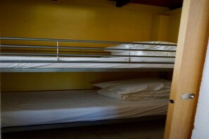A bunk bed room with a wooden door and a yellow wall. - Chalet in Santa Cristina City Centre (Santa Cristina d'Aro)
