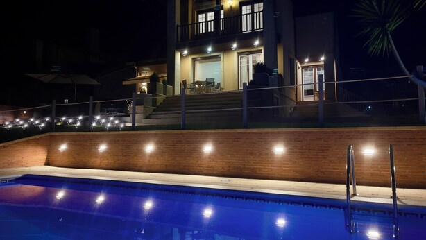 Une maison moderne à deux étages avec une piscine à l’avant.