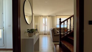 Un vaste espace de vie comprenant un escalier, un grand miroir et une vue sur l’extérieur.
