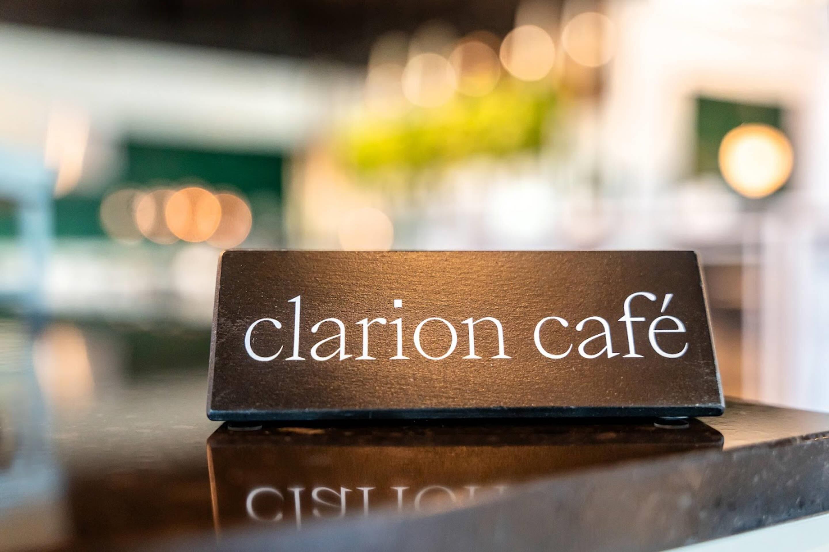Un cartello con la scritta 'clarion café' su una superficie in legno.
