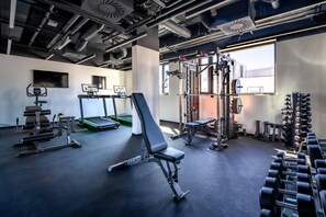 A gym with various exercise equipment, treadmills, and weightlifting stations.