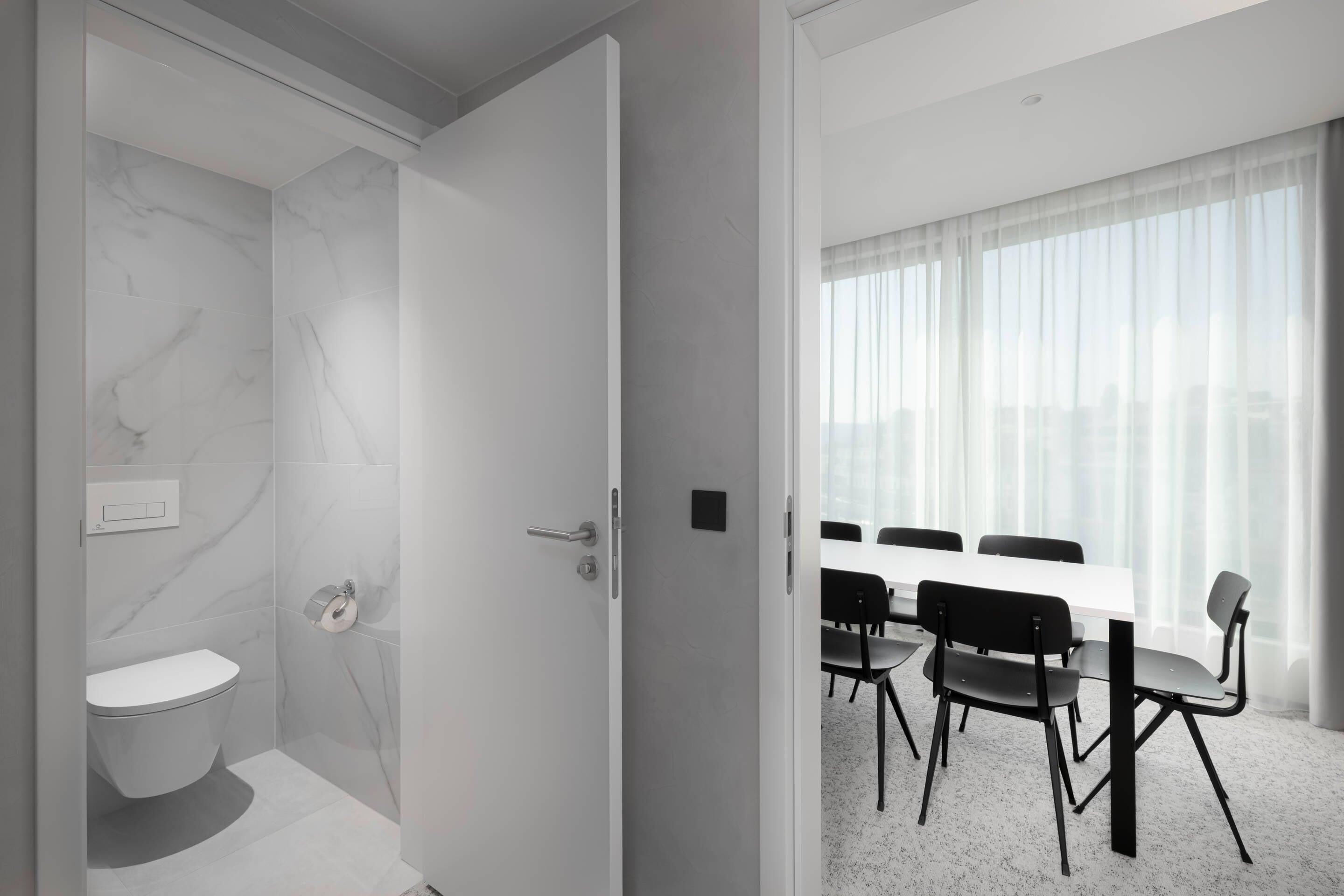 Un baño moderno con inodoro, ducha y porta papel higiénico.