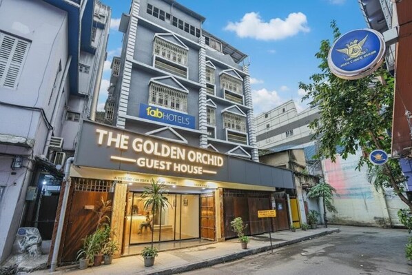 Un bâtiment portant une enseigne indiquant « The Golden Orchid Guest House » et « Lab Hotels ».
