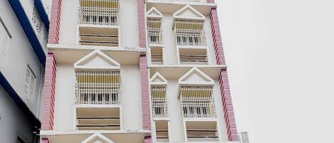 A multi-story building with balconies and barred windows.