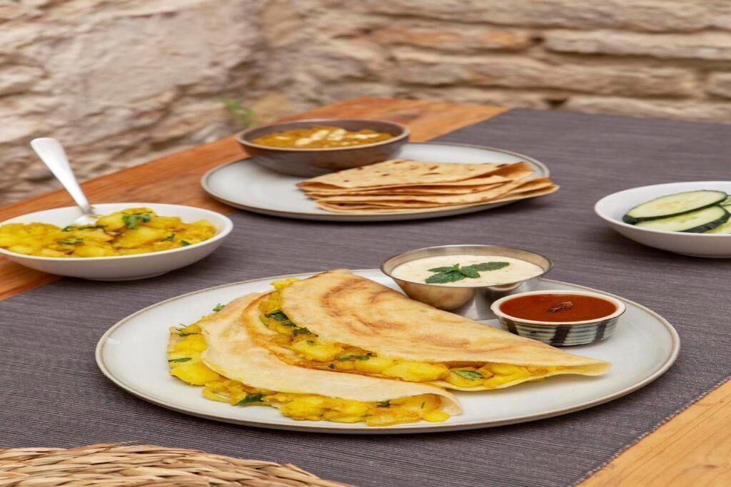 A meal with flatbreads, a bowl of dal, and a bowl of chutney.