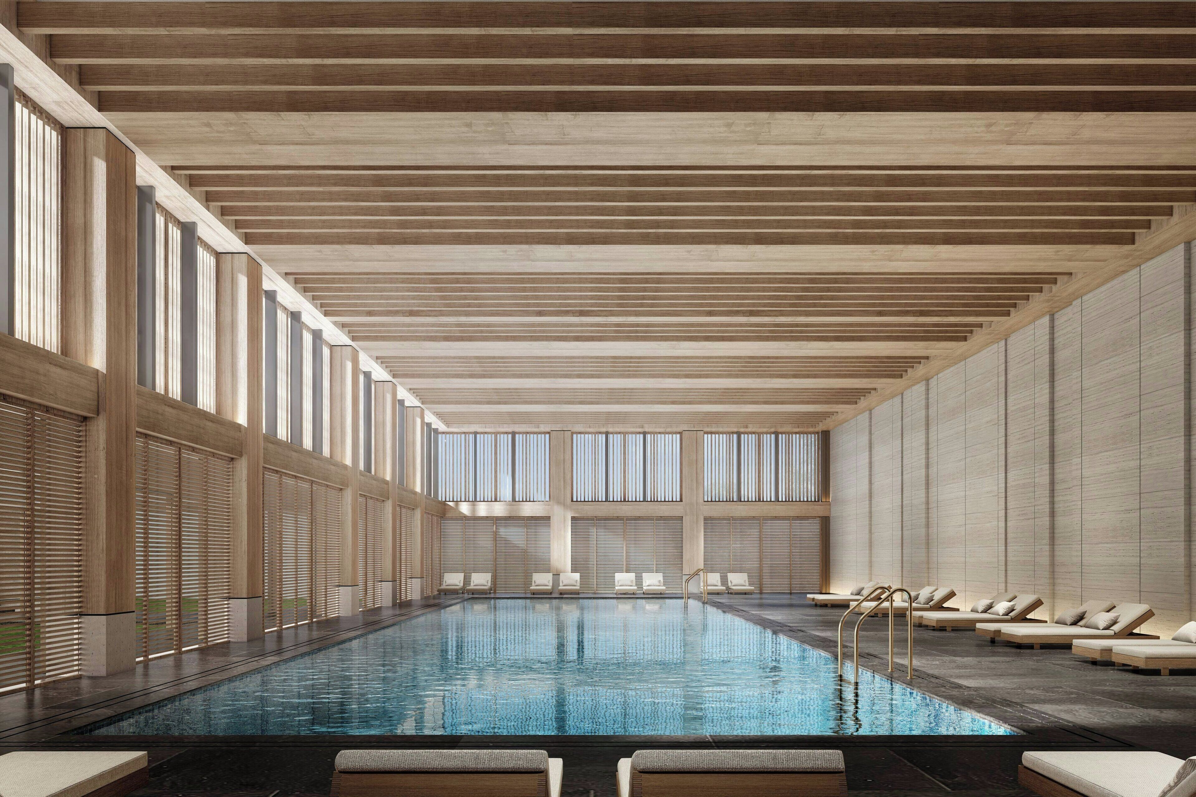 Una piscina techada, sillones reclinables de piscina