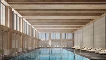 Una piscina techada, sillones reclinables de piscina