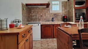 A compact kitchen with wooden cabinets, a built-in oven, and a window above the sink.