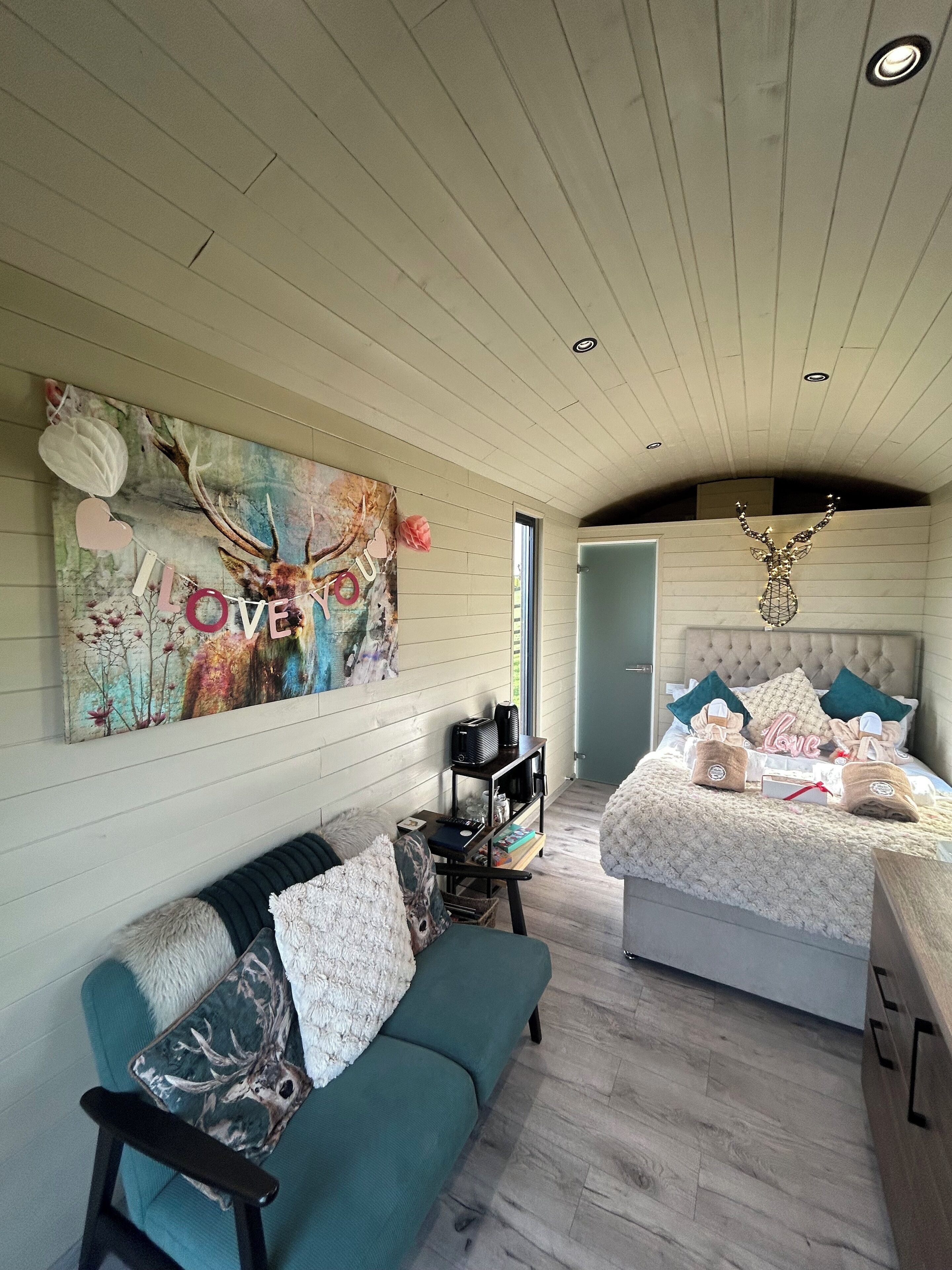 A cozy room with a bed, a sofa, and a painting on the wall.