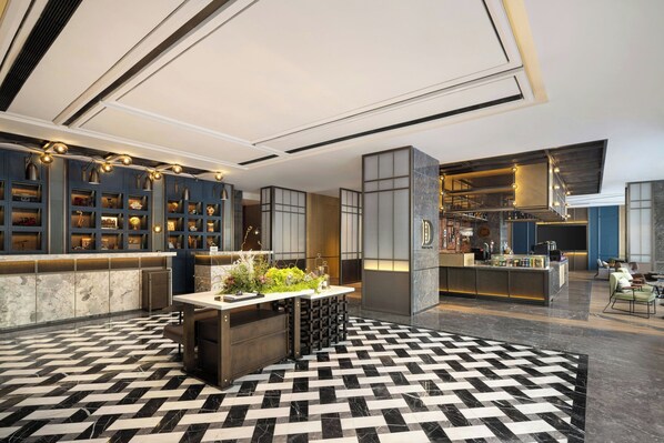 A modern hotel lobby with a check-in counter, seating area, and a bar. - Four Points by Sheraton Harbin City Center (Harbin)