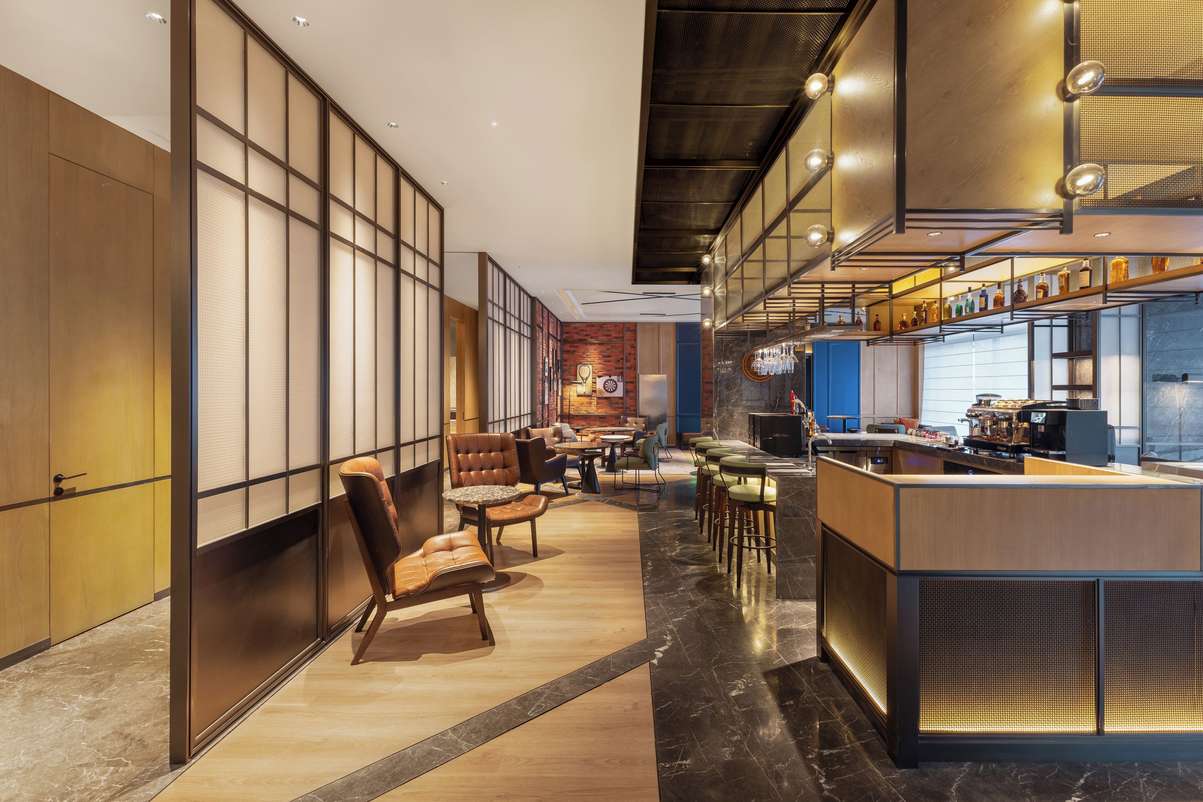 A modern interior with a bar area, seating, and a view of the city.