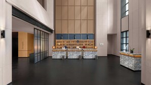 A spacious lobby with a high ceiling, a reception desk, and a seating area with a large window. - Four Points by Sheraton Qingtian (Lishui)