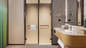 Une salle de bain moderne avec un meuble-lavabo aux lignes courbes, un grand miroir et un porte-serviettes.