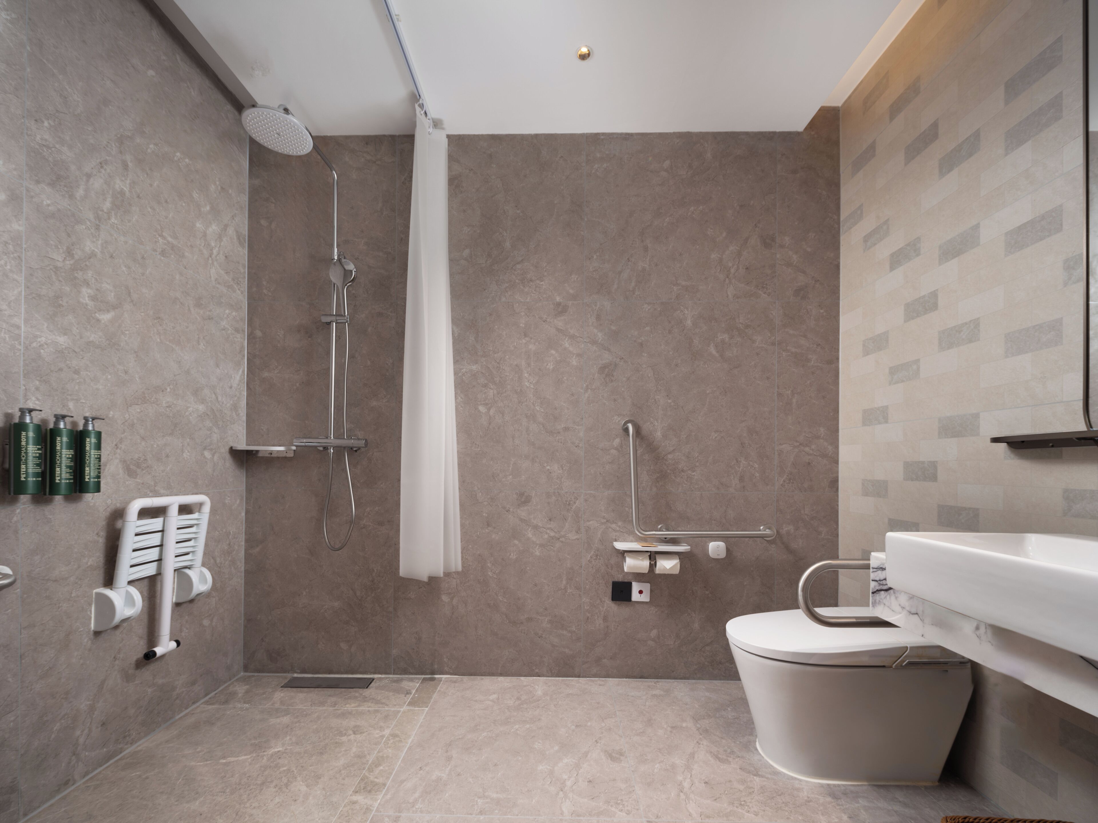 A modern bathroom with a shower, toilet, and sink.